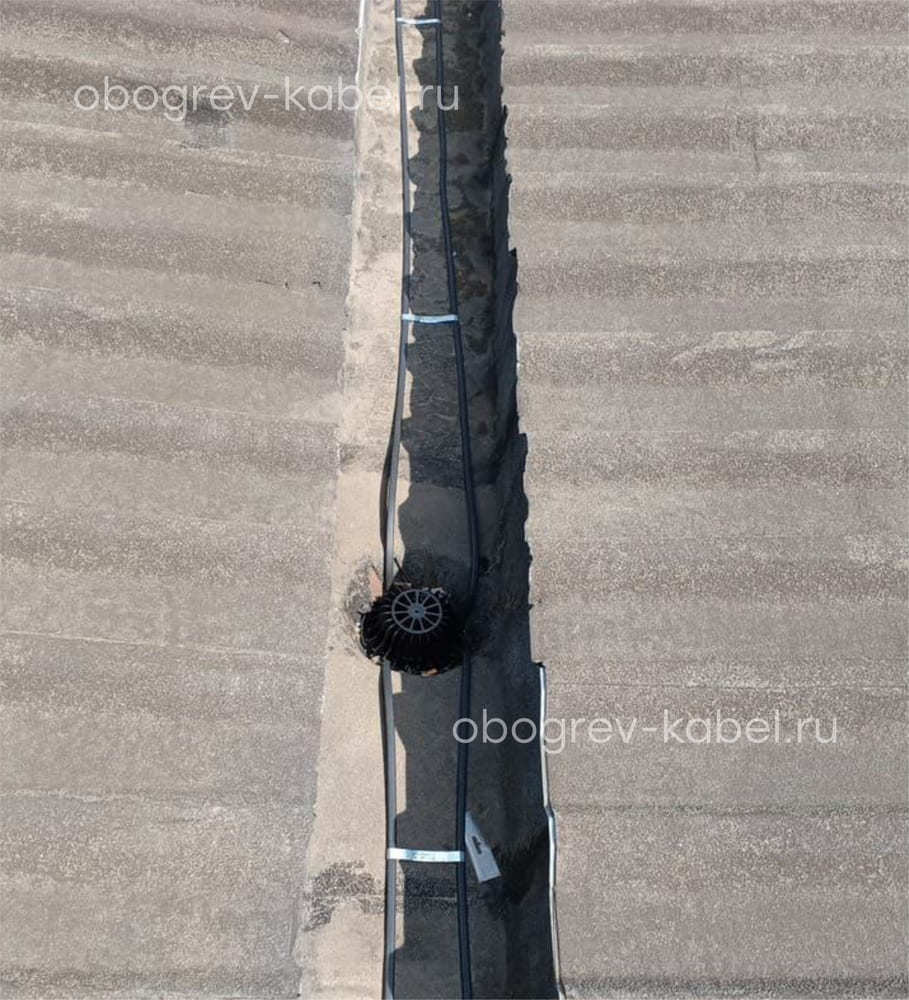 Обогрев внутренней водосточной трубы на кровле с желобом между двумя зданиями